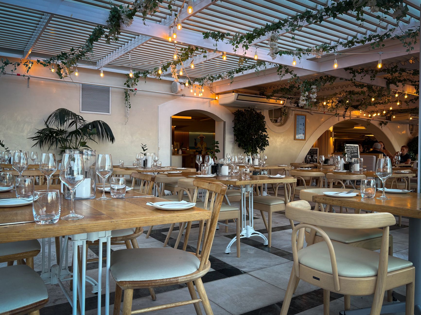 Elegantes Restaurantinterieur mit warmem Licht und grünem Blattwerk